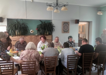 Uczestnicy spotkania świątecznego przy stole.