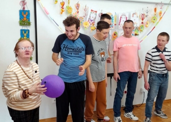 Uczestnicy biorą udział w zabawie z piłką.