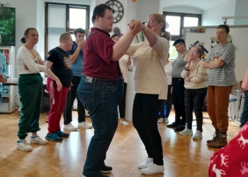 Uczestnicy spotkania tańczą.