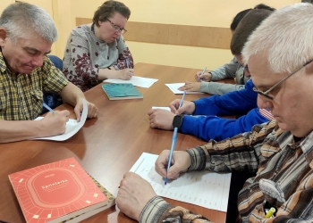 Uczestnicy spotkania piszą na kartkach nowe słowa z rozsypanych liter. 