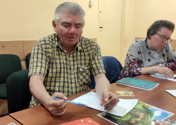 1Uczestnicy siedzący przy stole wybierają z kolorowych obrazków te, które będa przydatne do wspólnego opowiadania.