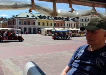 Zwiedzanie Zamościa. W tle stare kamienice Zamościa.
