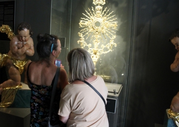 Dwie uczestniczki wycieczki ogladaja zabytkową monstrancję w Kościele Dominikanów.