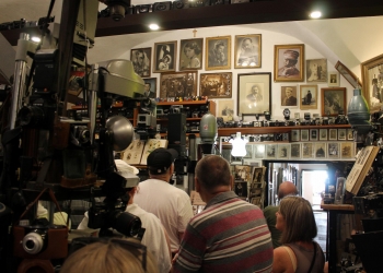 Zwiedzanie Muzem Fotografii. Na pierwszym planie zwiedzający, w tle stare fotografie portretowe.