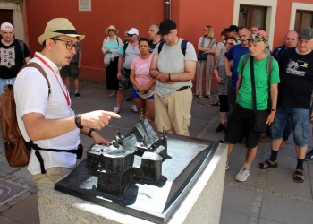 Przed wejściem do Kościoła Dominikanów przewodnik opowiada historię klasztoru.