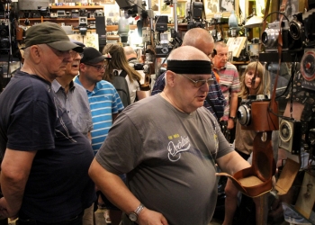 Zwiedzający ogladają zabytkowy sprzęt fotograficzny.