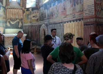 Przewodnik opowiada zwiedzającym historię kaplicy i fresków.