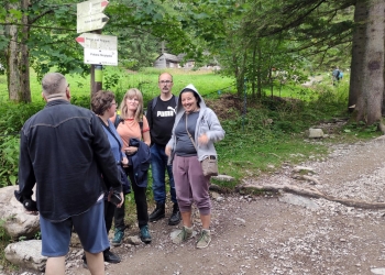 Wspólna fotografia. W tle chaty pasterskie.