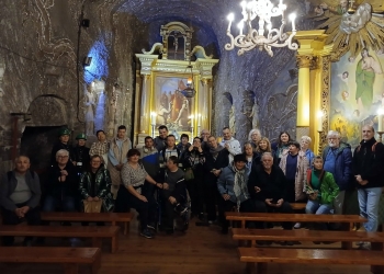 Uczestnicy pozują do fotografii w kaplicy w kopalni. W tle główny ołtarz.