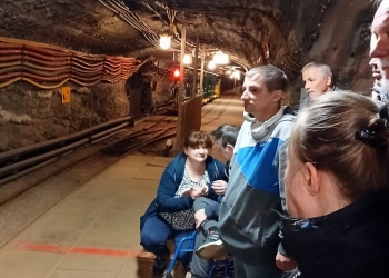 Uczestnicy stoją w korytarzu kopalni.