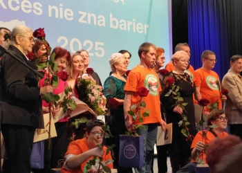 Wspólna fotografia osób wyróżnionych w konkursie. Uczestnicy stoją na scenie. W tle baner nawiązujący tematycznie do tresci konkursu.