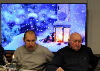 uczestnicy spotkania przy stole. W tle świąteczna dekoracja.