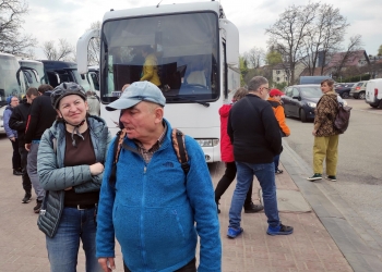 Uczestnicy wycieczki na parkingu przed kopalnią soli. W tle autokar.